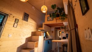 Pièce de vie de la Tiny House Basalte avec espace repas et canapé d'angle