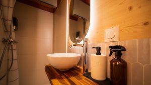 Salle de bain de la Tiny House Basalte avec vasque et miroir éclairé