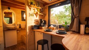 Salon de la Tiny House Basalte avec canapé d'angle convertible