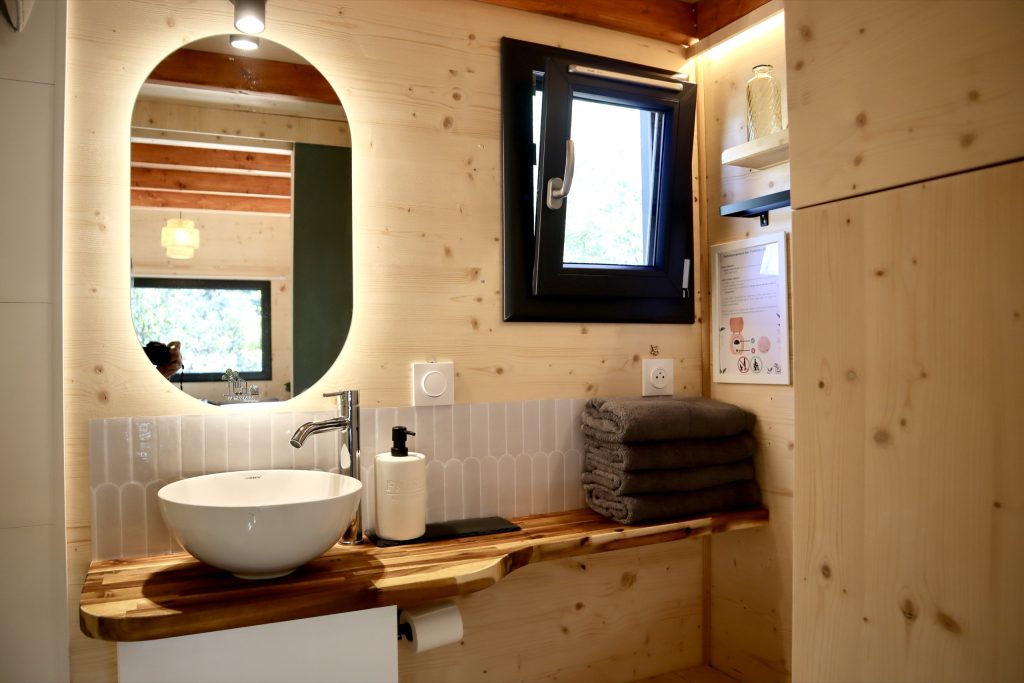 Salle de bain de la Tiny House Basalte avec vasque et miroir éclairé