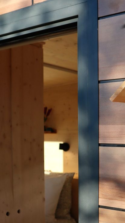 Entrée de la Tiny House Sainte-Victoire avec porte coulissante et enseigne en bois