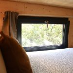 Lit double à l'étage de la Tiny House Basalte avec fenêtre sur la forêt