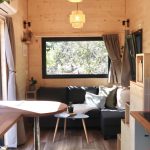Pièce de vie de la Tiny House Basalte avec espace repas et canapé d'angle
