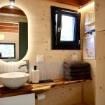 Salle de bain de la Tiny House Basalte avec vasque et miroir éclairé