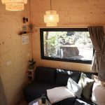 Salon de la Tiny House Basalte avec canapé d'angle convertible